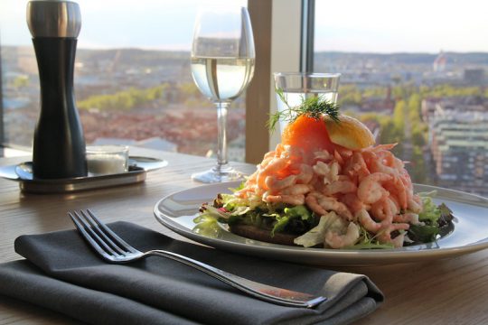 Stor räkmacka, ett glas vin och vacker utsikt